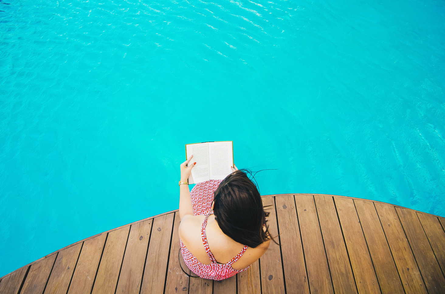 Woman Reading a Book by the Pool